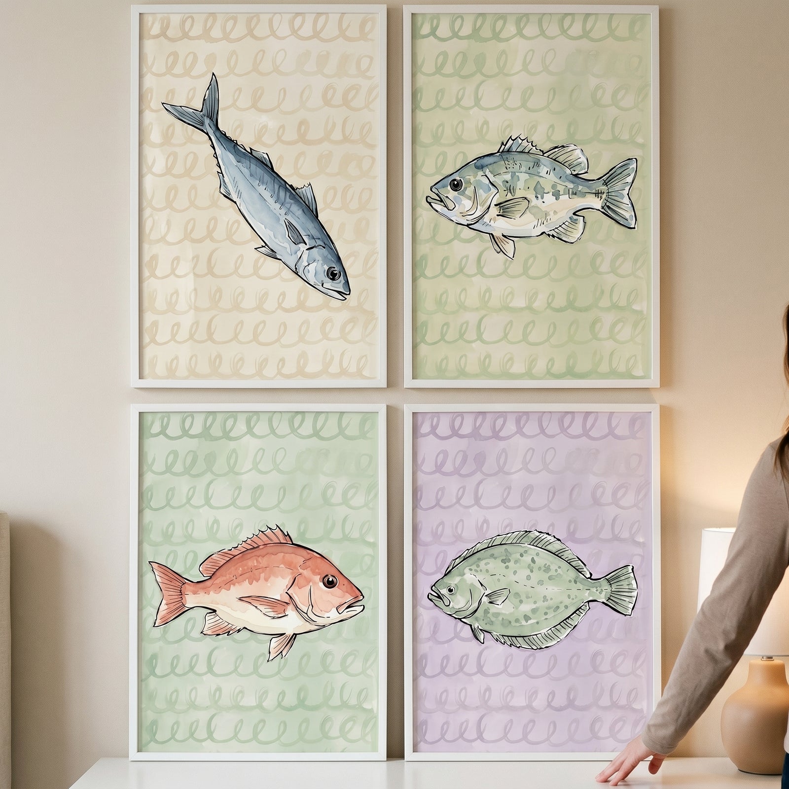 Muted watercolor loop fish wall art set of 4 with a mackerel, bass, snapper, and flounder in white frames on a wall.