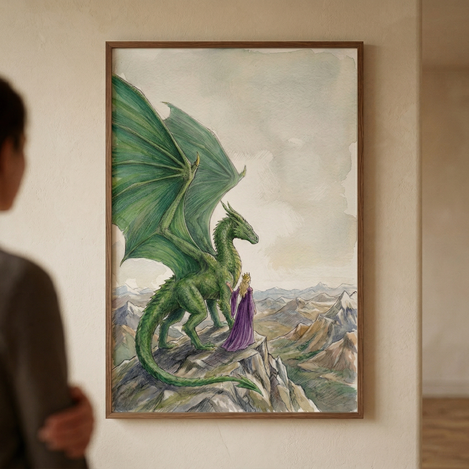 A watercolor fantasy illustration depicts a large green dragon and a person in a long purple robe standing on a jagged mountain peak. The dragon has expansive green wings and scaly skin, looking out toward a range of distant, snow-capped mountains. Beside it, the smaller figure is seen from behind, wearing a floor-length purple gown and a golden crown. The scene is rendered with soft colors and delicate textures. The work is showcased in a simple brown wooden frame, hung on a light-colored wall. 