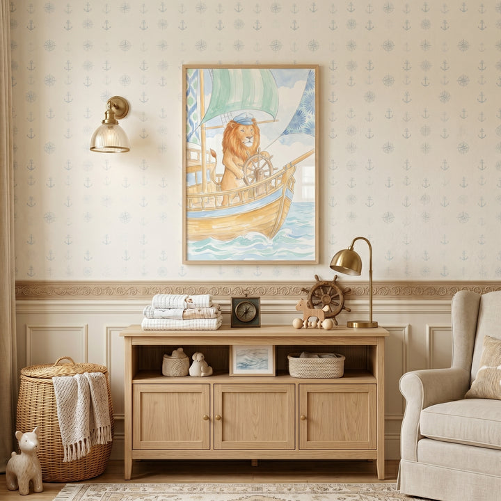Nautical captain lion wall art hangs above a wood cabinet in a nursery with anchor wallpaper and a plush armchair.