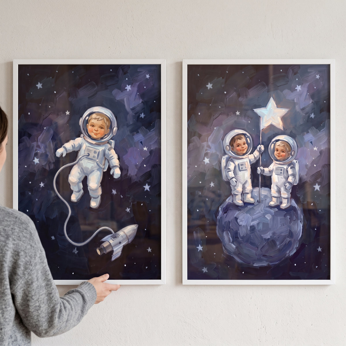 Navy blue child astronaut wall art set of 2 featuring children in suits floating by a rocket and standing on a moon.
