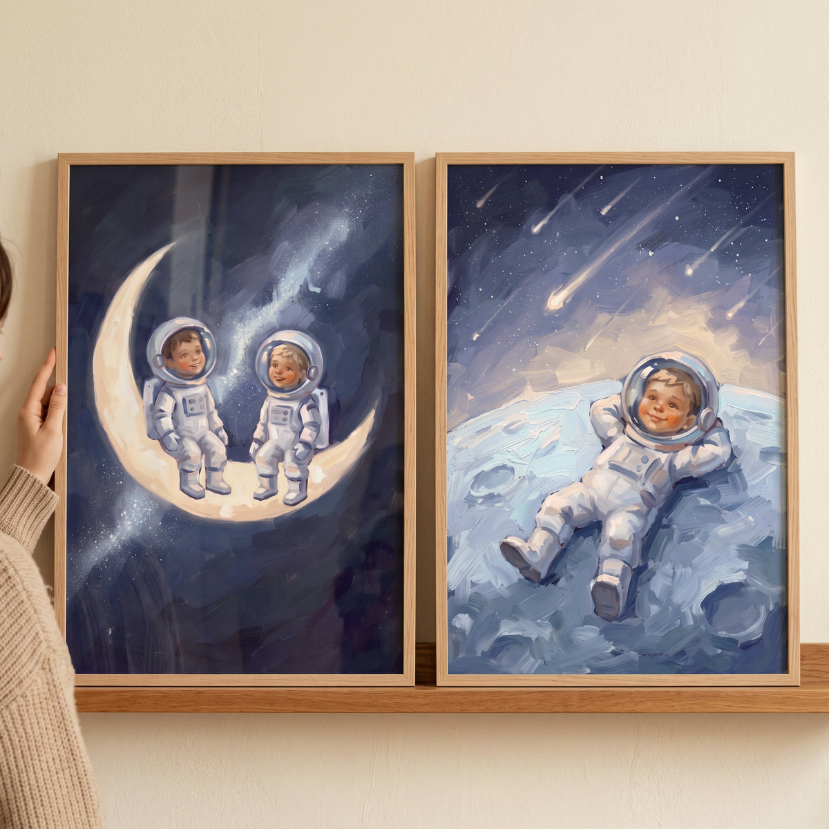 Navy space baby astronaut wall art set of 2 featuring infants on a crescent moon and one resting under shooting stars.