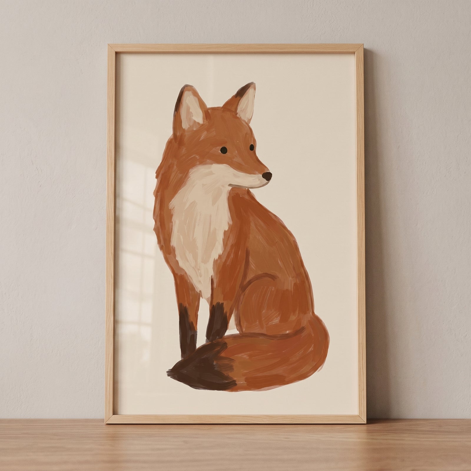 Neutral sitting fox wall art features an orange and cream fox looking back, in a light wood frame on a minimalist wall.