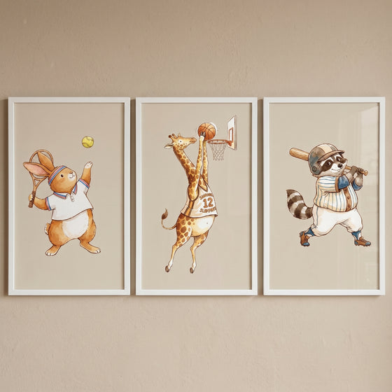 Neutral tone sports animals wall art set of 3 with a rabbit, giraffe, and raccoon playing tennis, basketball, and baseball.