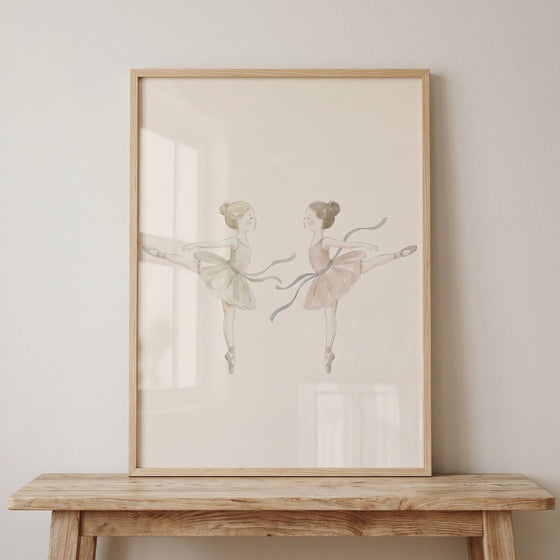 Framed neutral watercolor ballerina wall art featuring two dancers in soft tutus resting on a rustic wooden bench.
