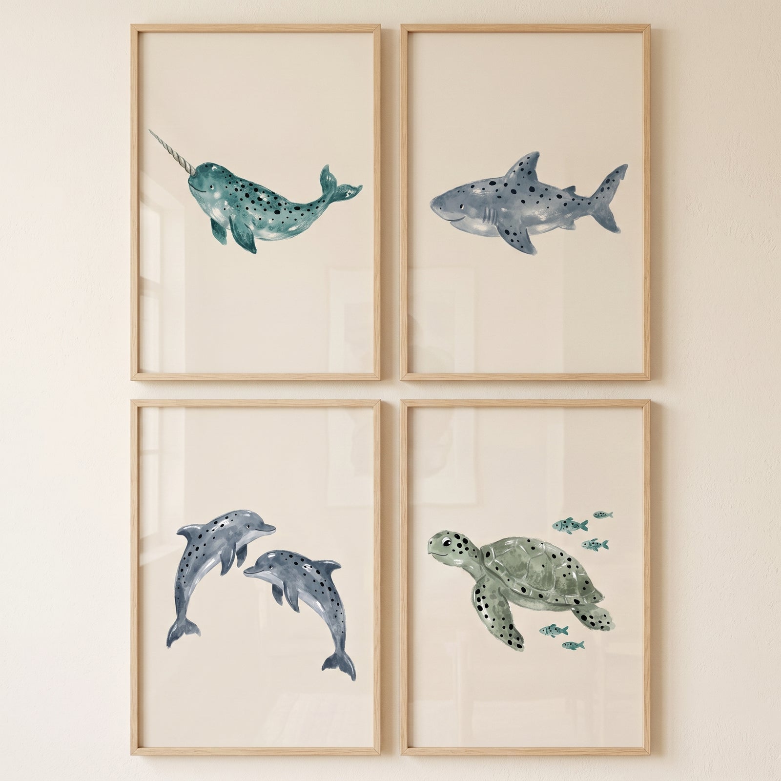 Neutral watercolor sea creature wall art set of 4 featuring a narwhal, shark, dolphins, and a sea turtle in wood frames.