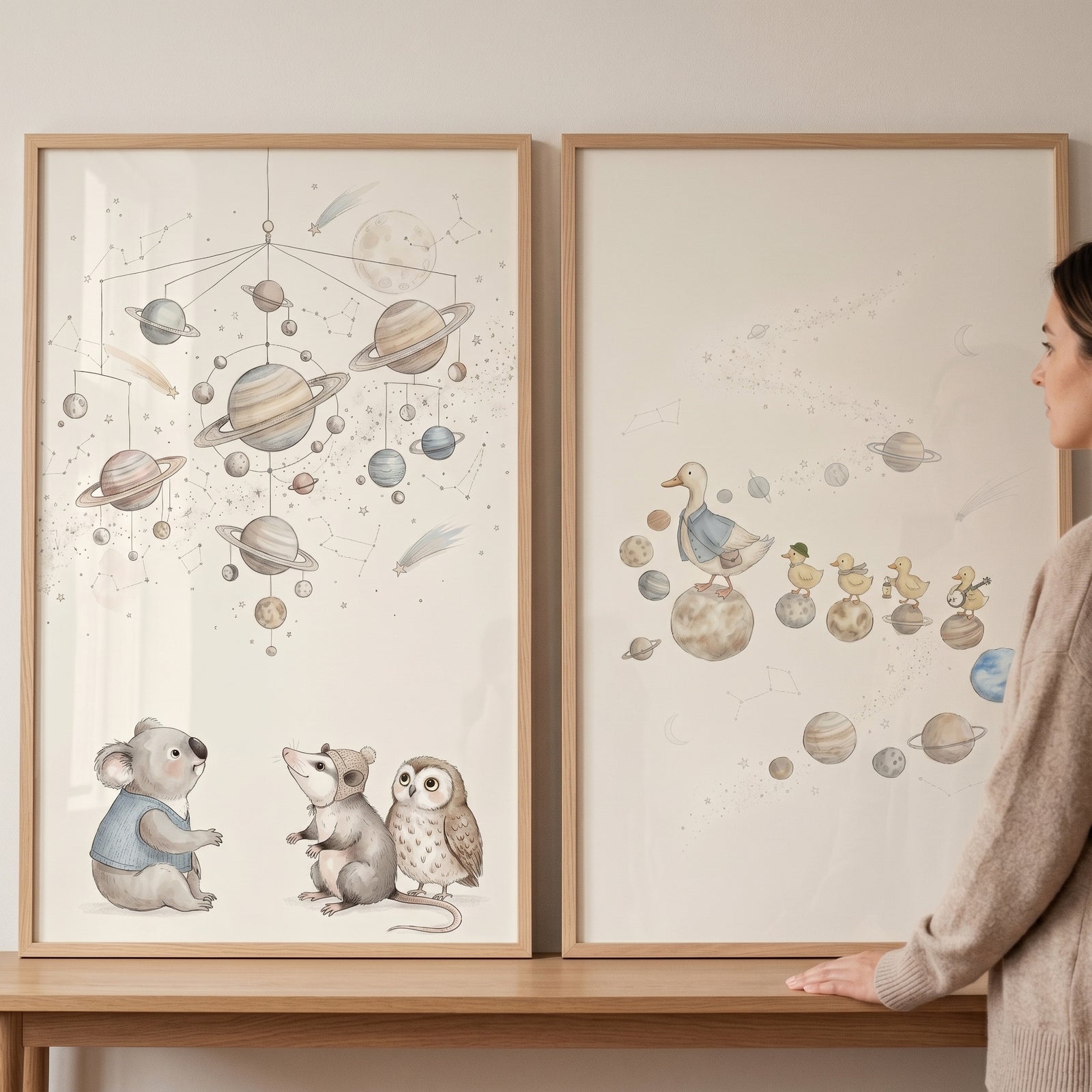 Neutral watercolor space animals wall art set of 2 featuring planets with a koala, owl, and ducks in light wood frames.