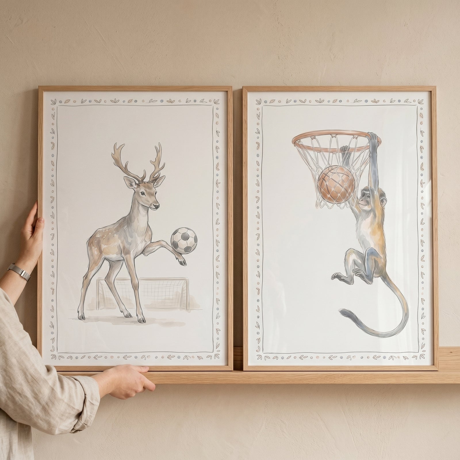 Neutral watercolor sports animals wall art set of 2 showing a deer with a soccer ball and a monkey at a basketball hoop.