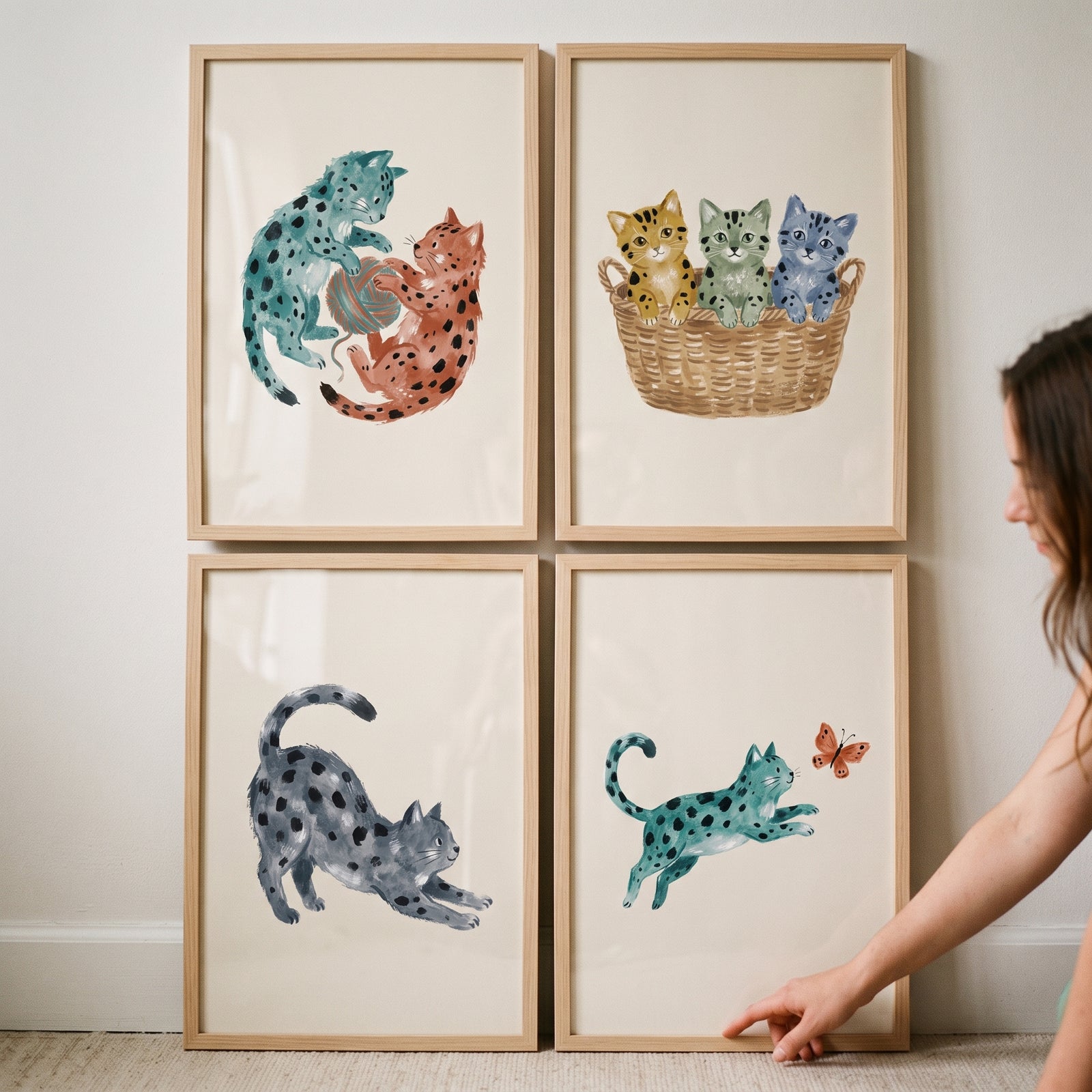 Neutral watercolor spotted cat wall art set of 4 featuring playful felines and kittens in light wood frames.