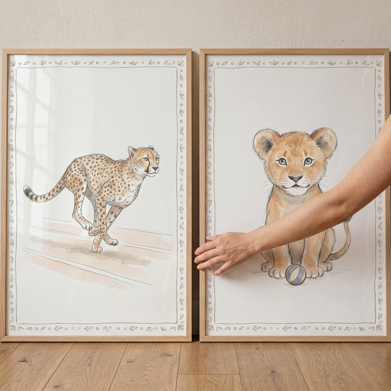 Neutral watercolor wild cat wall art set of 2 featuring a running cheetah and a sitting lion cub in wooden frames.