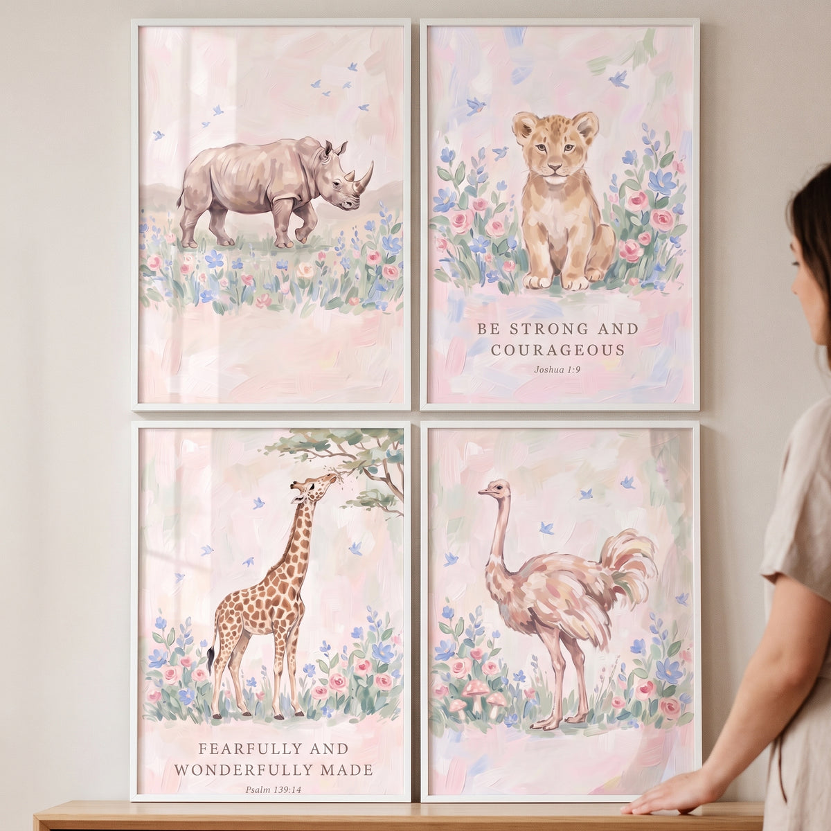 Nursery blush safari animals wall art set of 4 featuring a rhino, lion cub, giraffe, and ostrich in soft floral scenes.