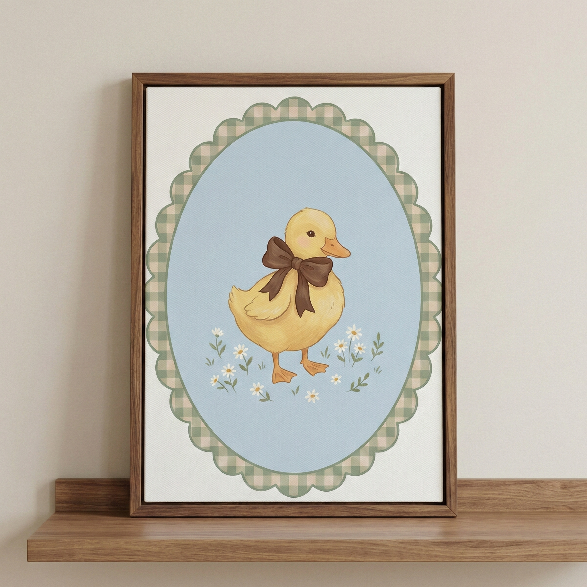 A sweet nursery-style illustration featuring a soft yellow duckling adorned with a large brown bow. The duckling stands among tiny white daisies set against a light blue oval backdrop. Encircling the oval is a decorative scalloped border with a green and cream gingham pattern. This artwork is displayed in a dark brown wooden frame, resting on a simple wooden shelf against a plain, warm-toned wall.