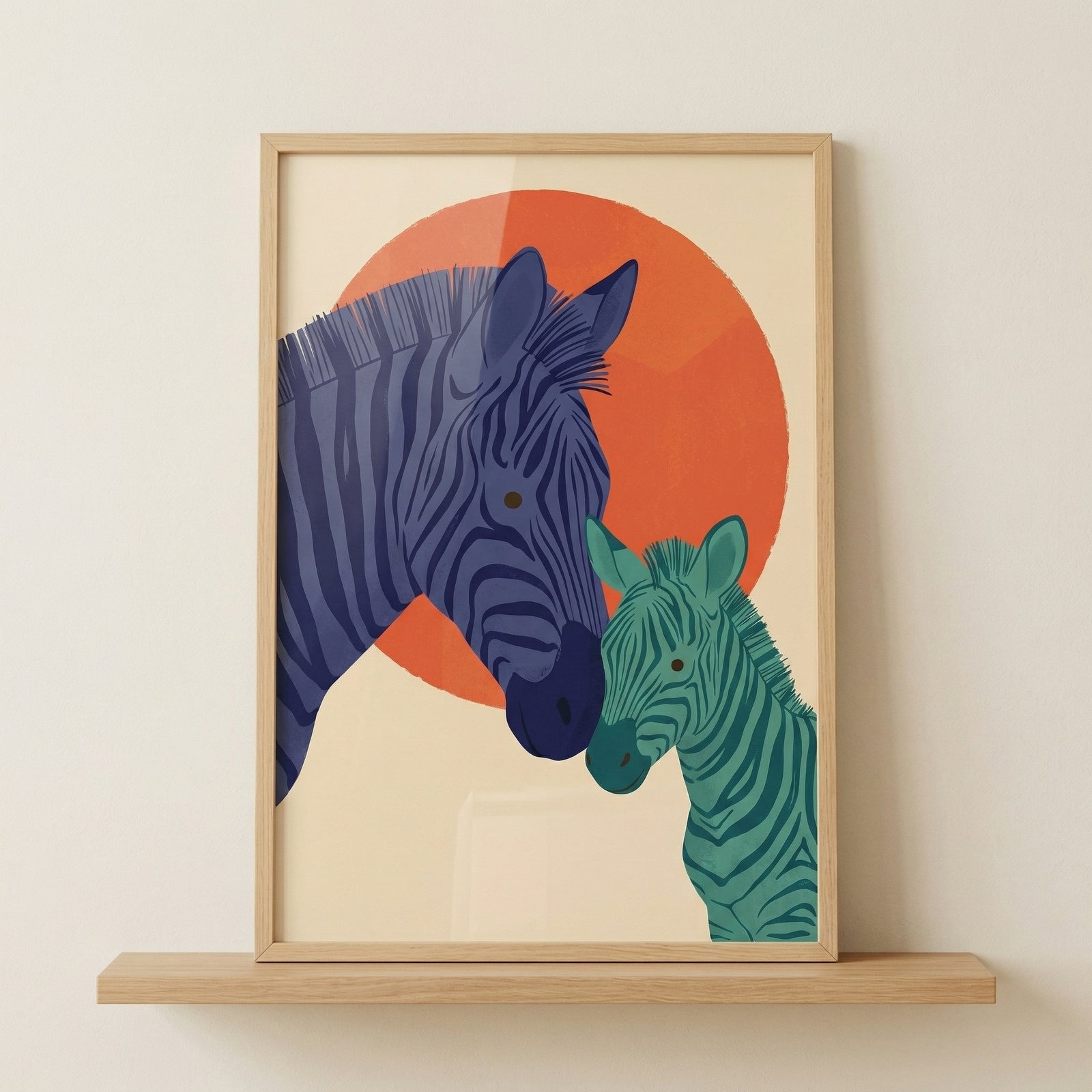 Framed illustration of a zebra and its foal gently touching heads in front of a large orange sun creating a warm and affectionate moment. The artwork sits on a wooden shelf and adds a soft safari theme to a nursery or child’s room.