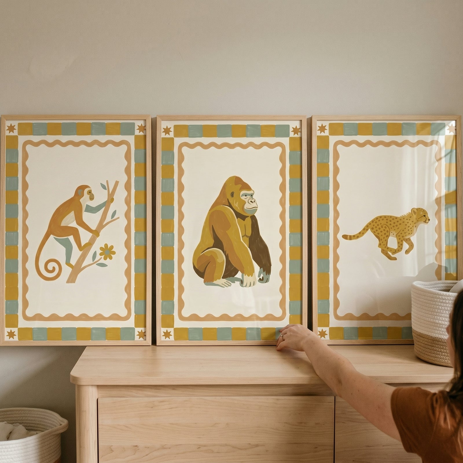 Ochre checkered savanna animals wall art set of 3 featuring a monkey, gorilla, and cheetah on a light wood dresser.