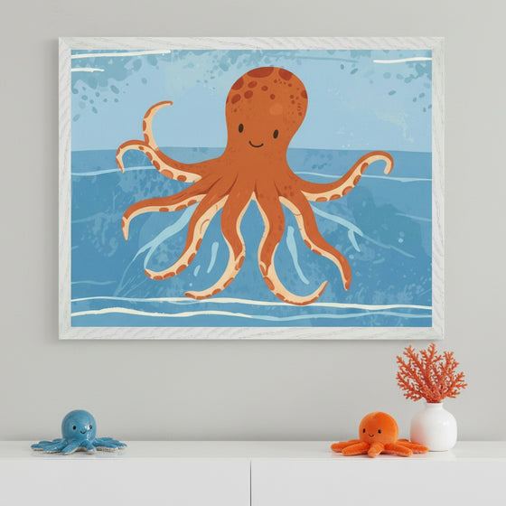 Modern kid's room with a white dresser. A large white-framed cartoon illustration of a smiling orange octopus swimming in blue water hangs centered above the dresser. On the dresser are a blue octopus plush, an orange octopus plush, and orange coral in a white vase.