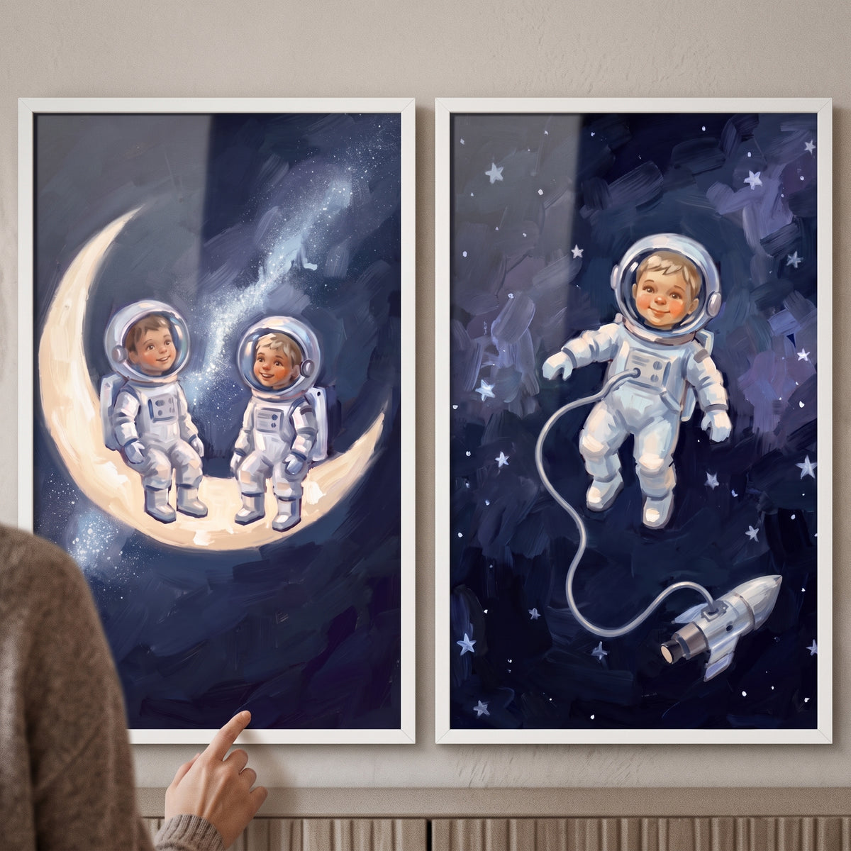 Hand pointing at an oil texture child astronaut artwork set of 2 featuring kids on a moon and floating among stars.