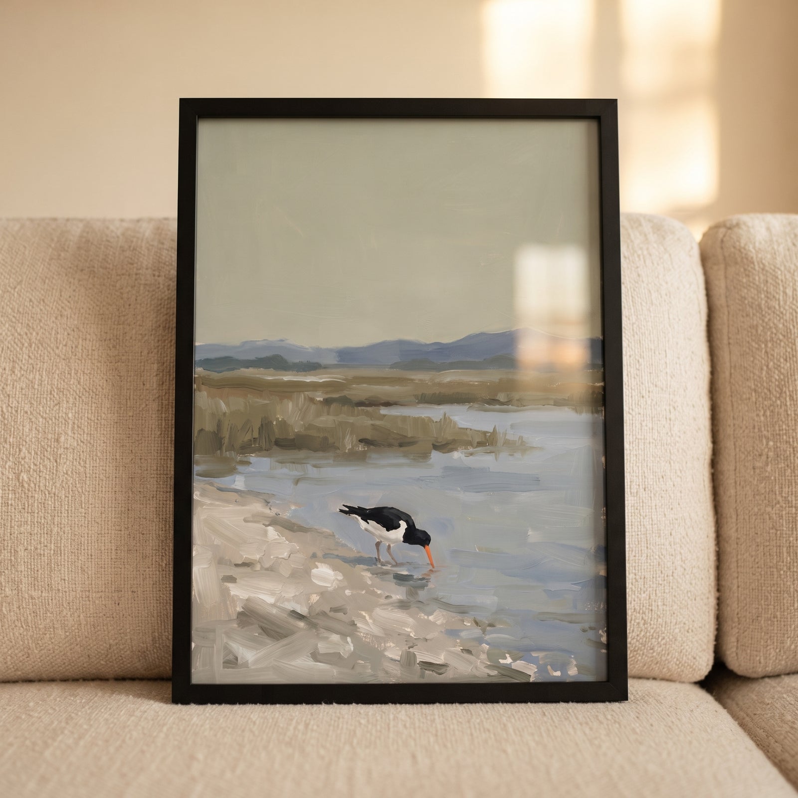 Framed orange beak oystercatcher bird wall art depicts a bird on a shore near marshy water and distant mountains.