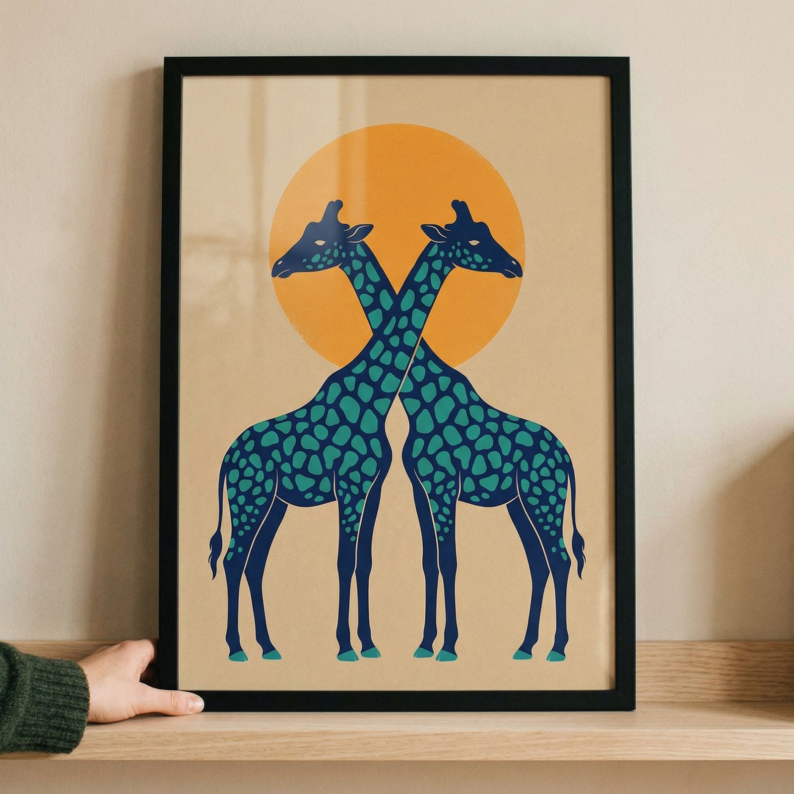 Framed illustration of two stylized giraffes standing side by side with their necks crossing in front of a warm orange sun. The symmetrical design and bold colors create a striking and playful focal point suitable for a modern nursery or kids room.