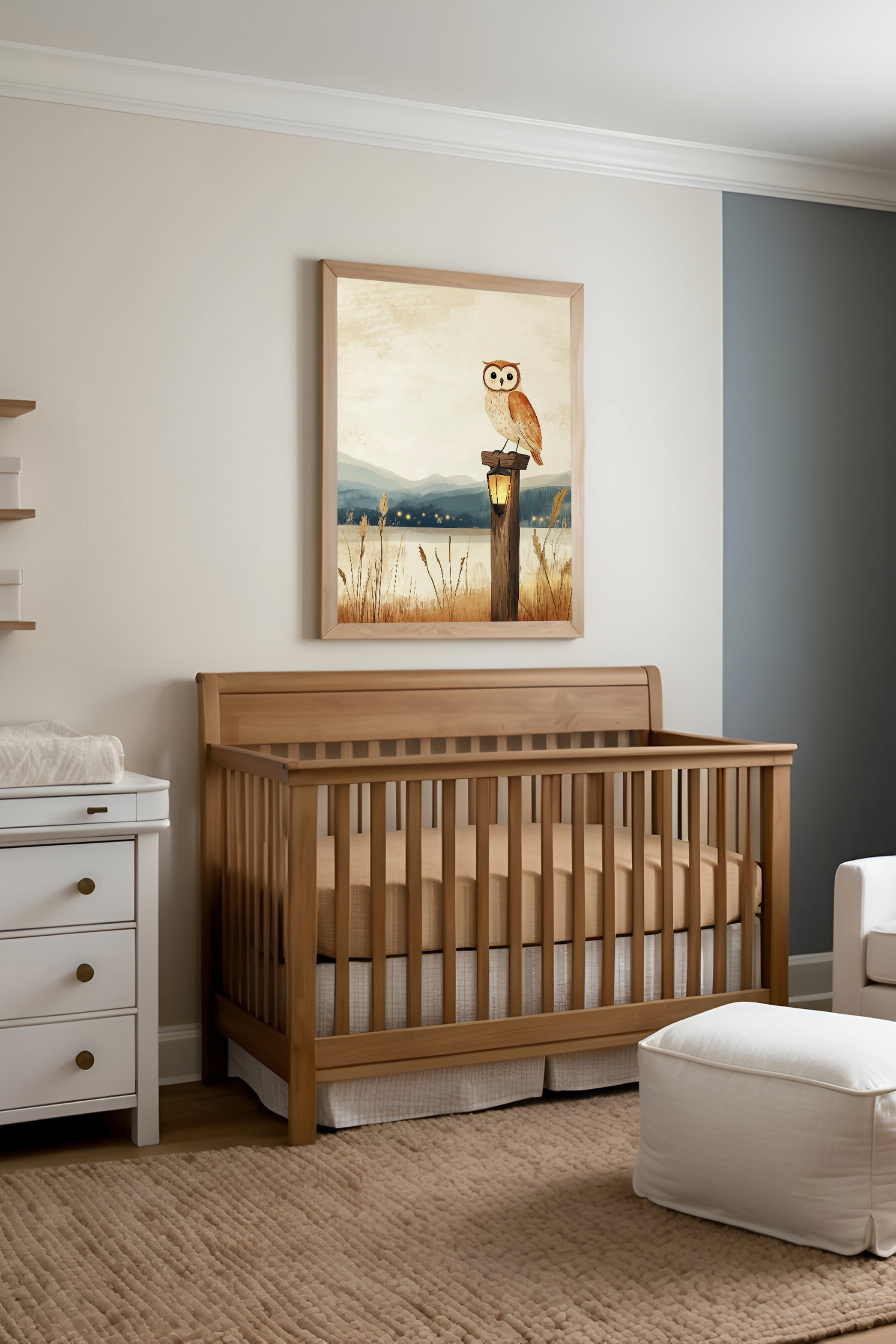 A cozy, modern nursery with neutral tones featuring a wooden crib, white furniture, and soft textures. Above the crib hangs a framed illustration of an owl perched by a lantern, complementing the room’s peaceful and inviting atmosphere.