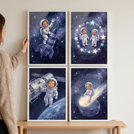A person hangs a painterly blue baby astronaut wall art set of 4 featuring infants in space suits and celestial objects.