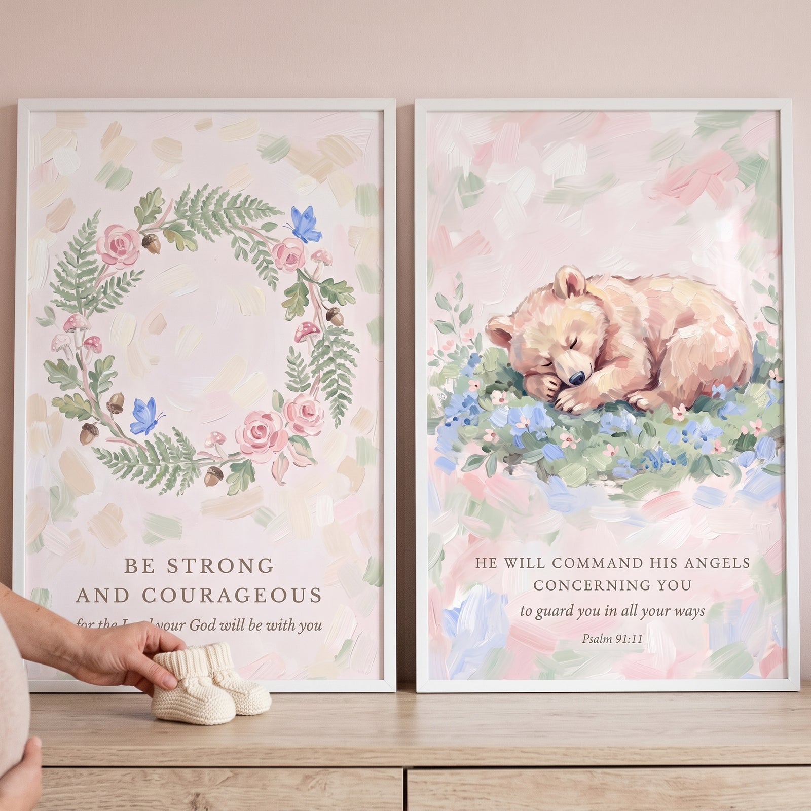 Painterly blush pink scripture bible wall art set of 2 featuring a floral wreath and a sleeping bear beside baby booties.