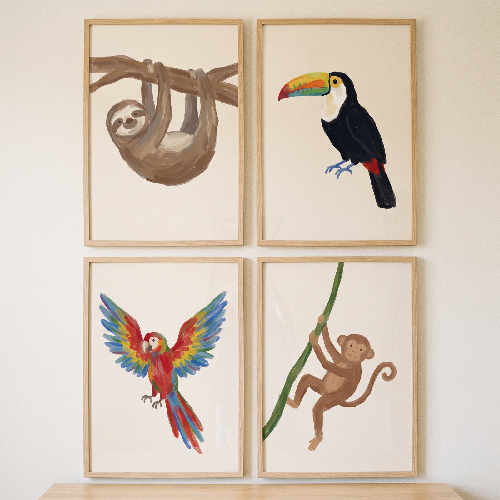Painterly neutral jungle animals wall art set of 4 featuring a sloth, toucan, parrot, and monkey in light wood frames.