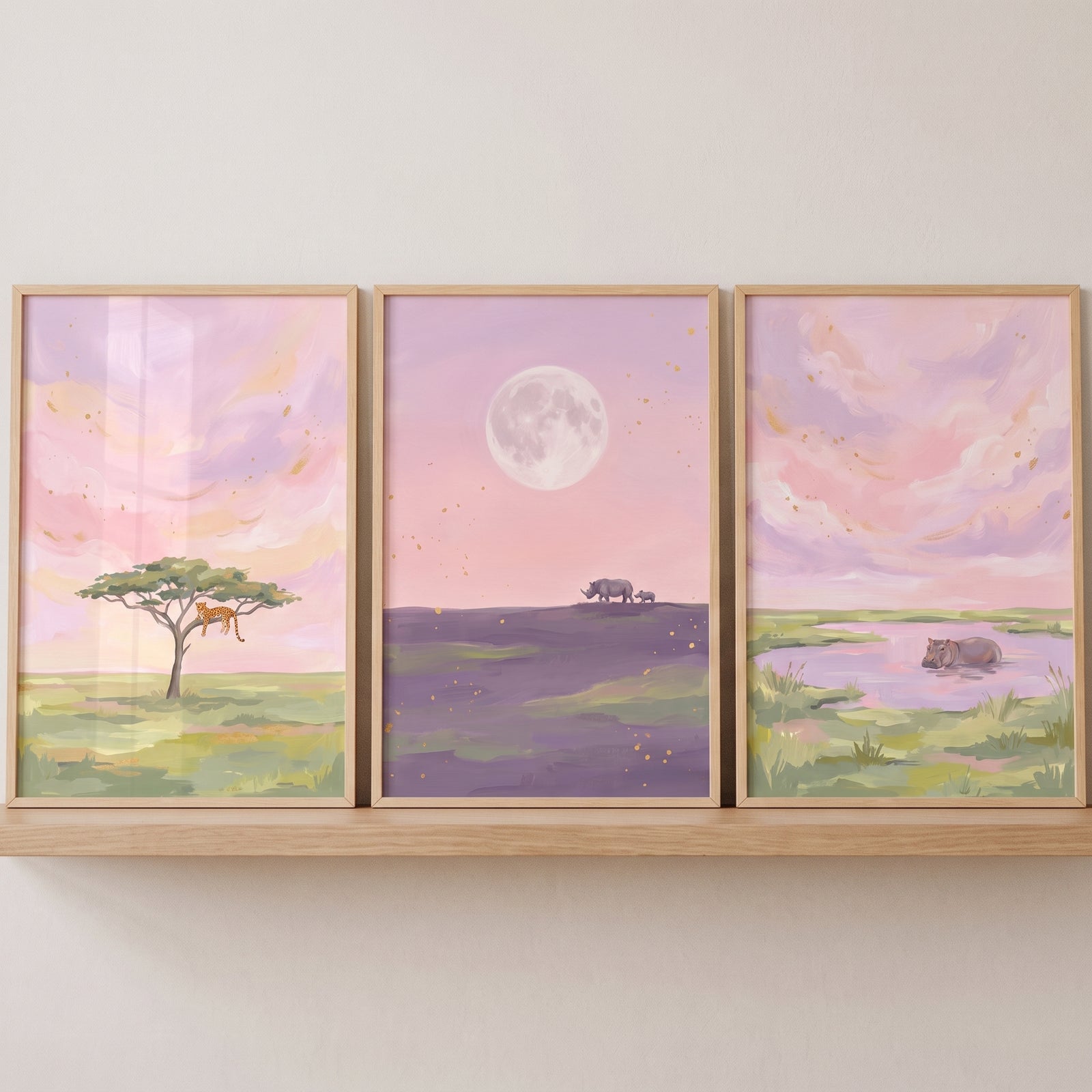Painterly pink safari animals wall art set of 3 depicts a leopard in a tree, rhinos at dusk, and a hippo in water.