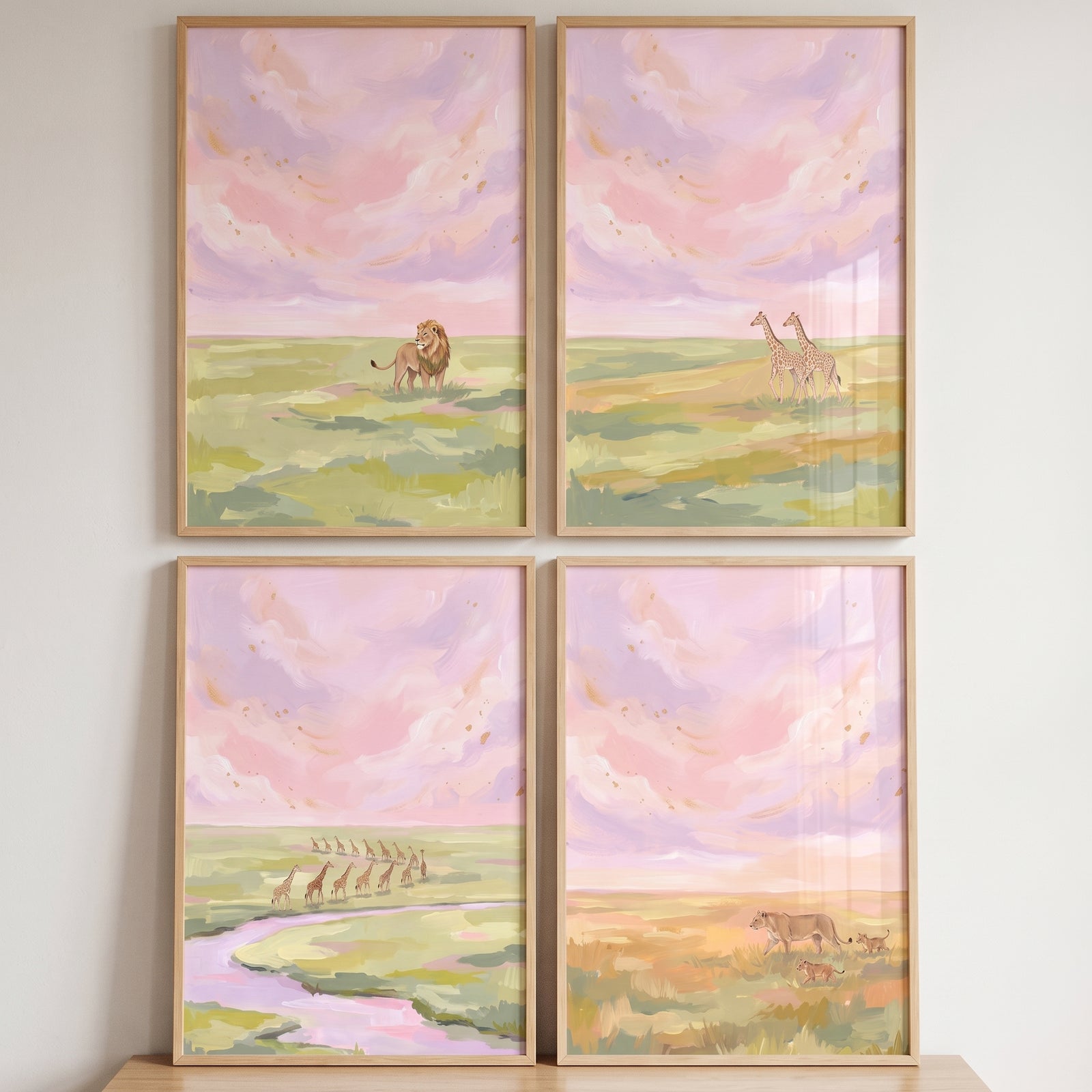 Lions and giraffes beneath pastel clouds are featured in this painterly pink savanna animals wall art set of 4.