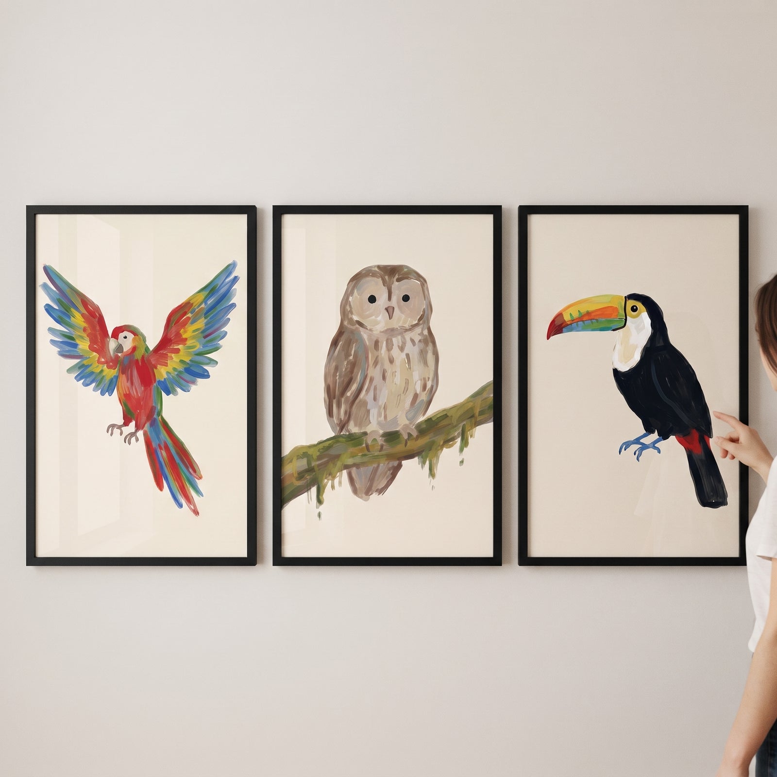 Painterly textured avian birds wall art set of 3 featuring a parrot, owl, and toucan in black frames on a wall.