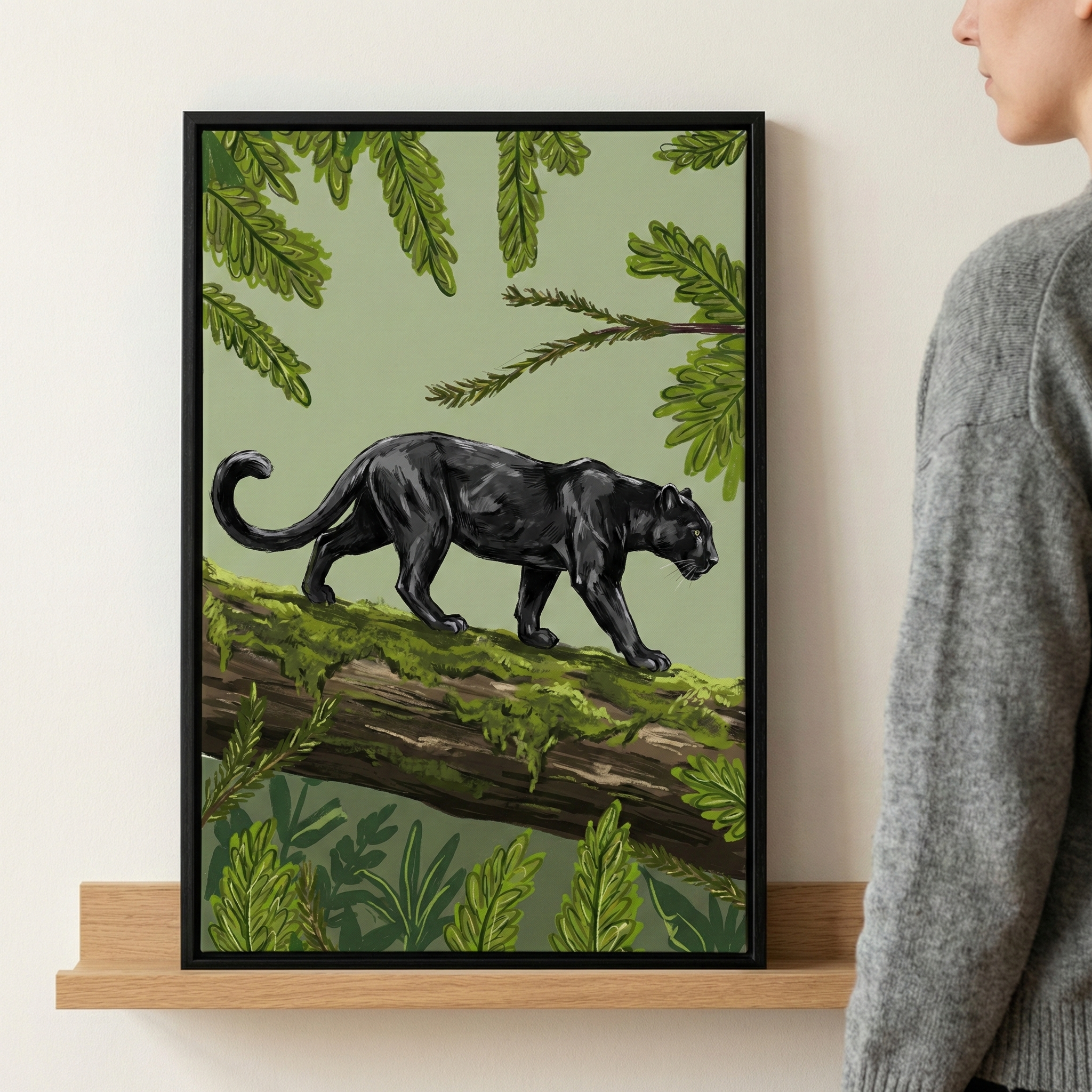 A person in a gray sweater observes a framed painting on a shelf, depicting a black panther walking gracefully along a moss-covered log, surrounded by lush green foliage against a light green background.