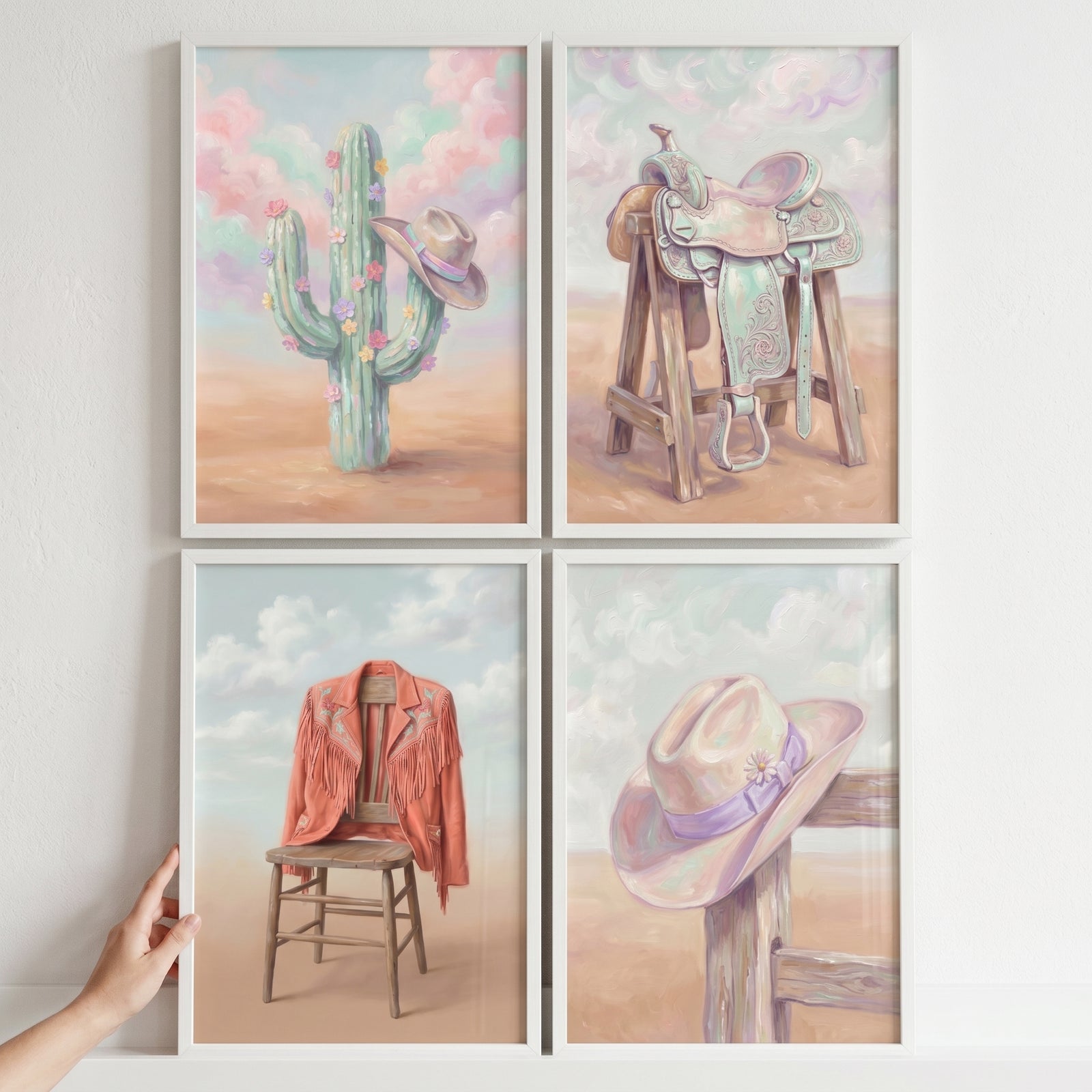 Pastel desert cowgirl gear wall art set of 4 features a cactus, a saddle, a fringed jacket on a chair, and a hat on a fence.