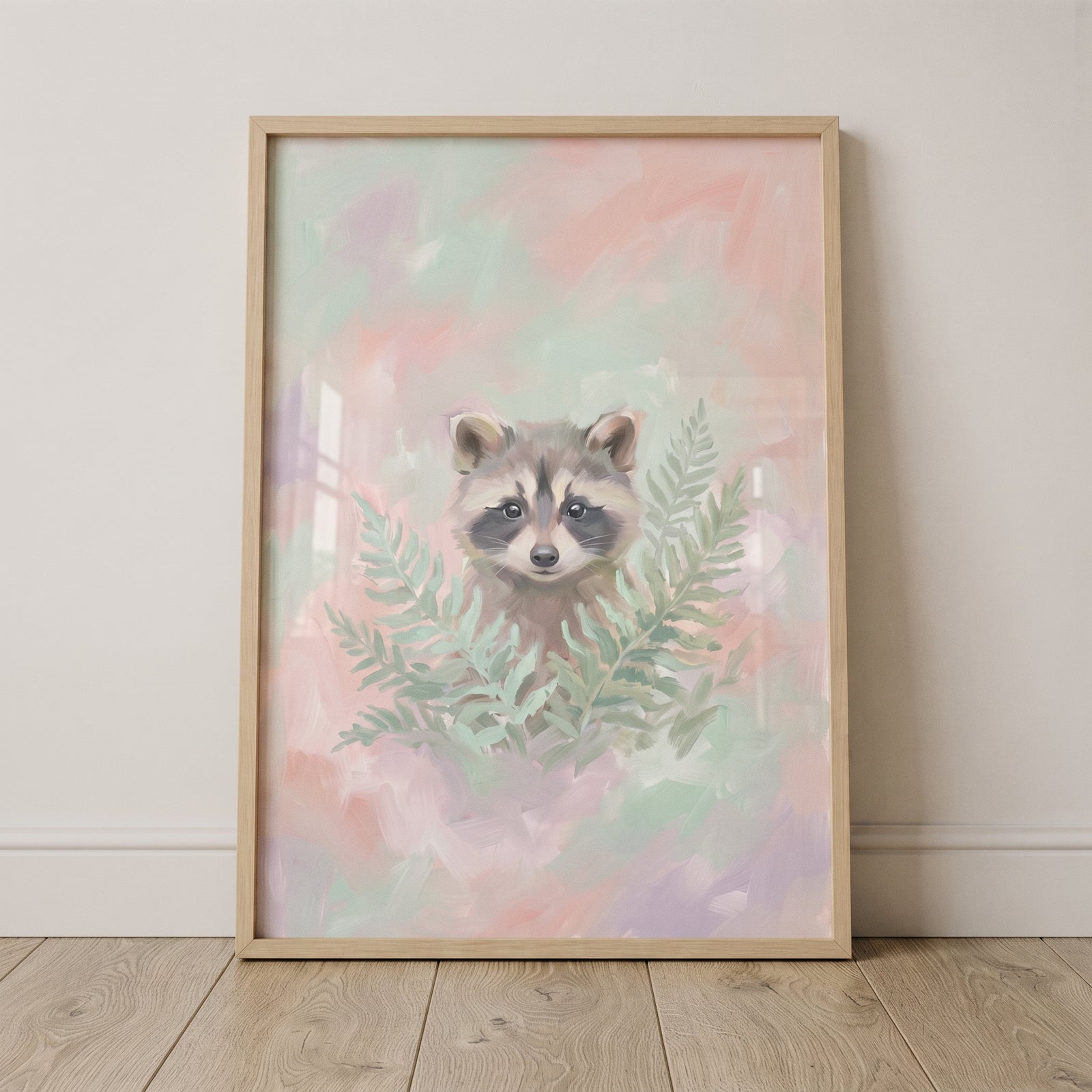 Pastel green fern raccoon wall art features a raccoon face peeking through ferns on a soft pink and green background.