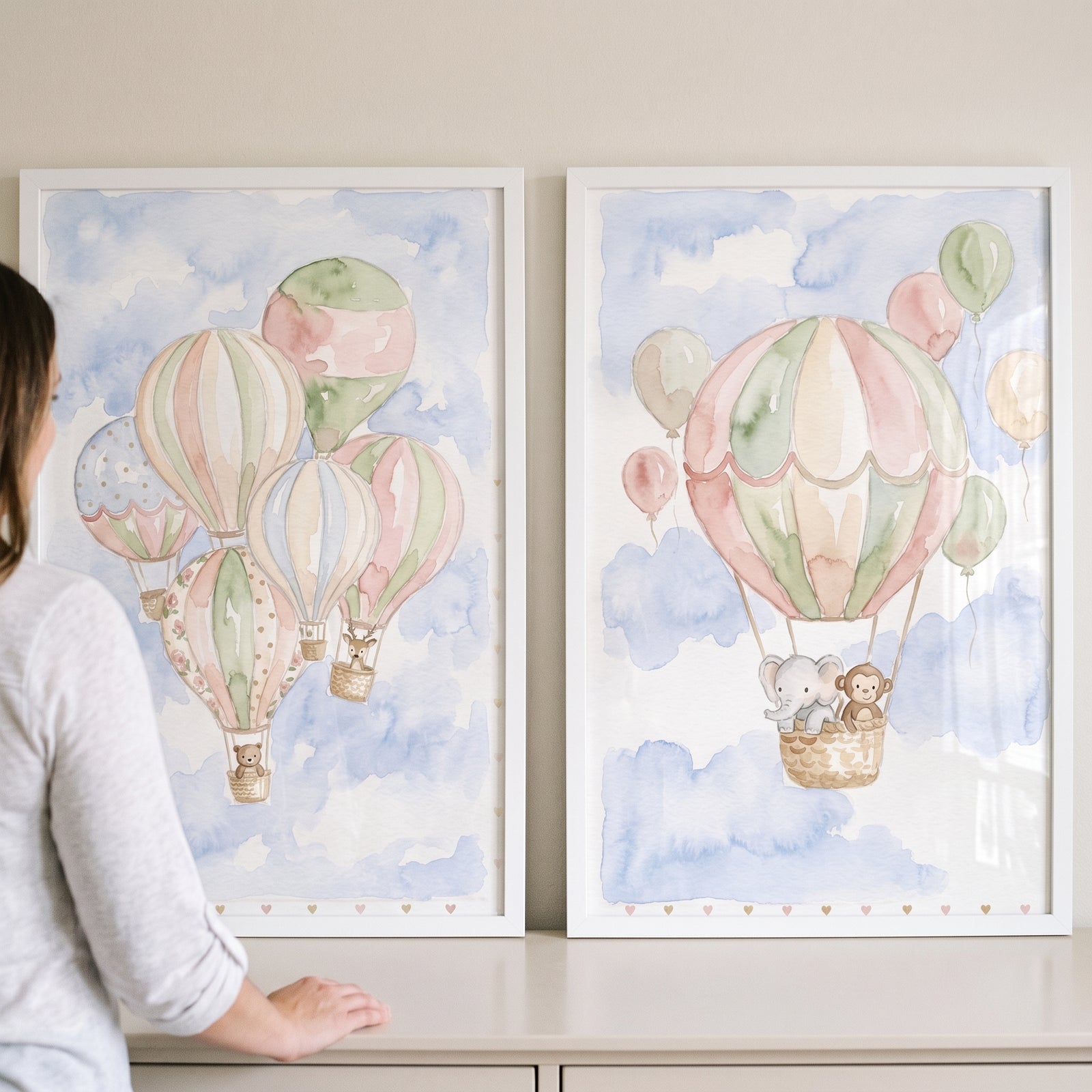 Pastel hot air balloon wall art set of 2 featuring watercolor baby animals floating in baskets through blue clouds.