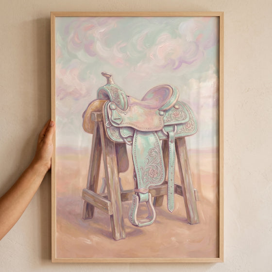 Pastel mint green saddle wall art featuring a floral western saddle on a wooden stand in a soft desert landscape.