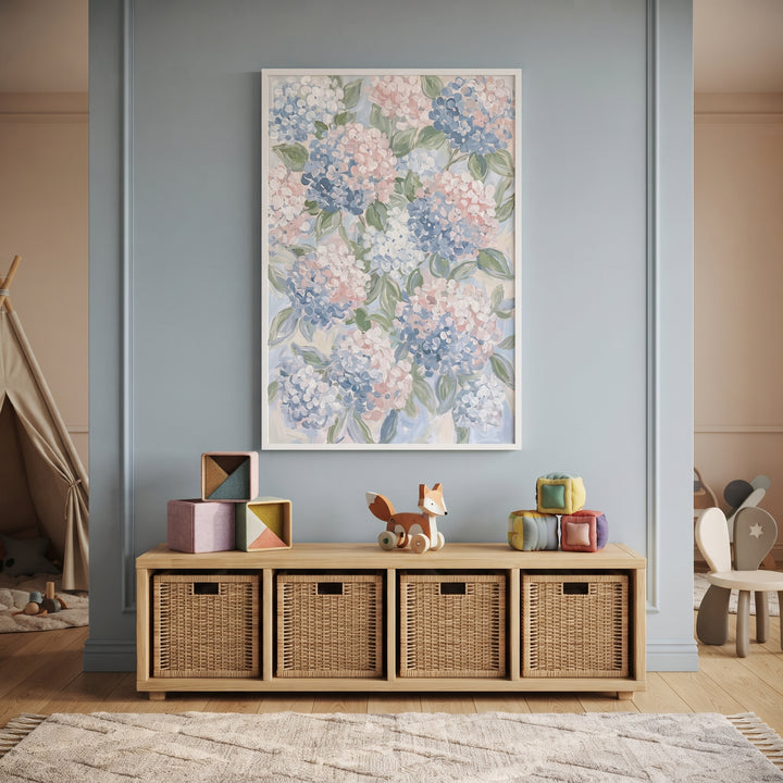 Pastel pink blue hydrangea floral wall art hangs above a wooden storage unit with baskets in a light blue nursery.