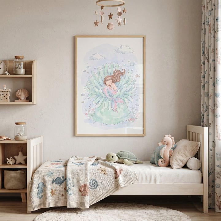 Pastel sea anemone mermaid wall art hangs above a child's bed with plush sea creature toys and an ocean-themed blanket.