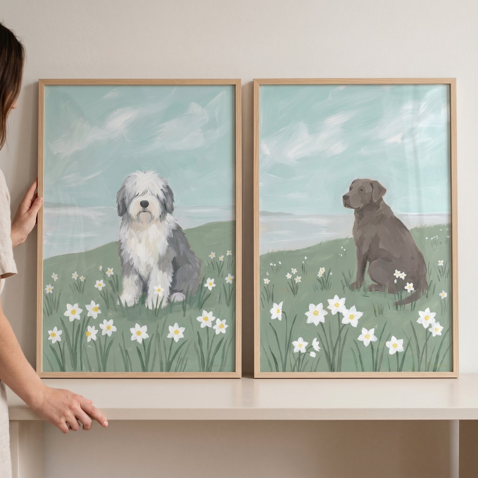 Pastel sky coastal dogs wall art set of 2 featuring a shaggy white dog and a brown dog in a field of white flowers.