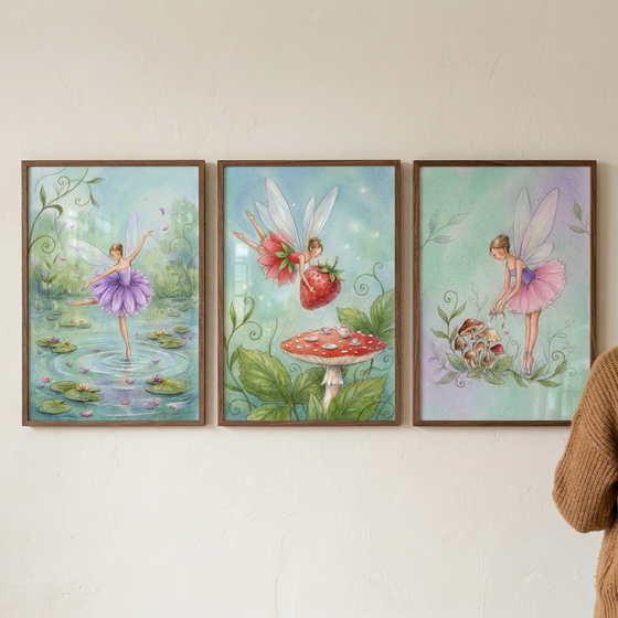 A triptych of three vertical framed illustrations hangs on a light-colored wall, featuring whimsical fairy-themed artwork in soft, watercolor tones. In the leftmost frame, a fairy wearing a purple tutu dances gracefully across the surface of a pond, surrounded by floating water lilies. The middle frame depicts two winged fairies flying through the air, carrying a large red strawberry above a red mushroom with white spots. 