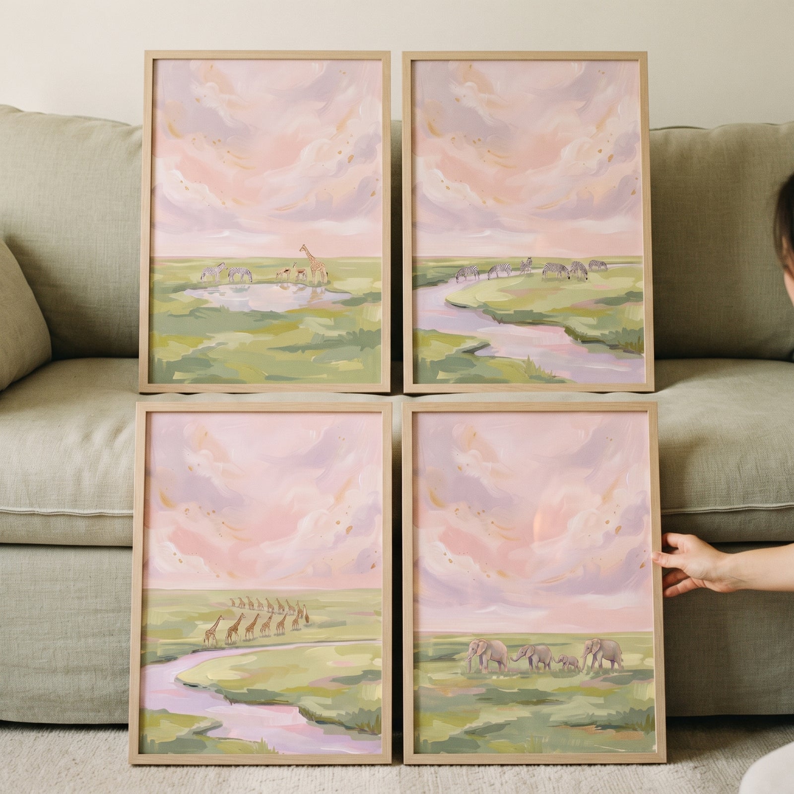 Pastel sunset savanna animals artwork set of 4 framed prints showing elephants and giraffes against a green sofa.