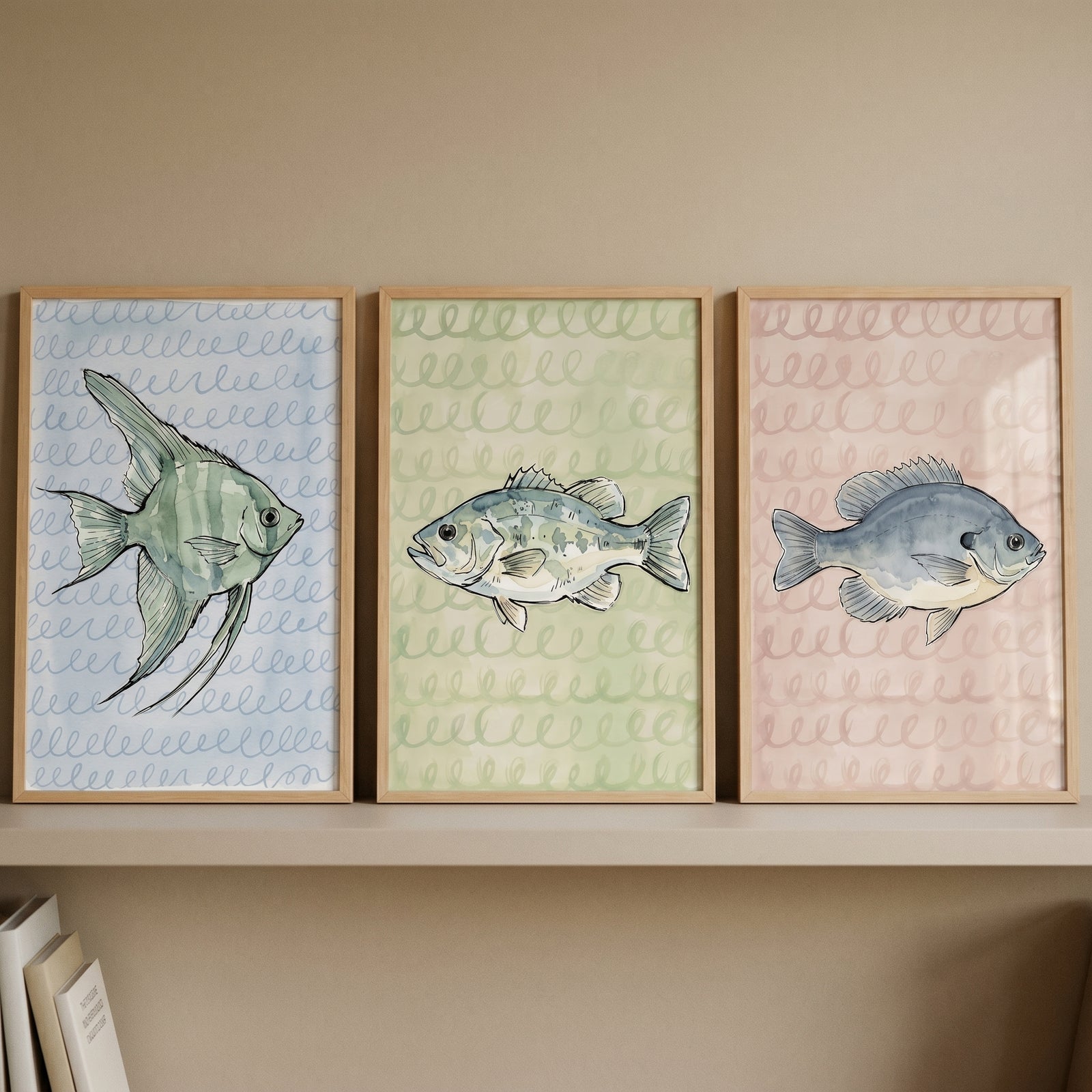 Pastel watercolor swirl fish wall art set of 3 features three framed illustrations of various fish on a shelf.