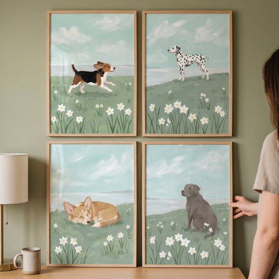 A pastoral spring meadow dog wall art set of 4 displays different breeds in flower fields on a green wall.