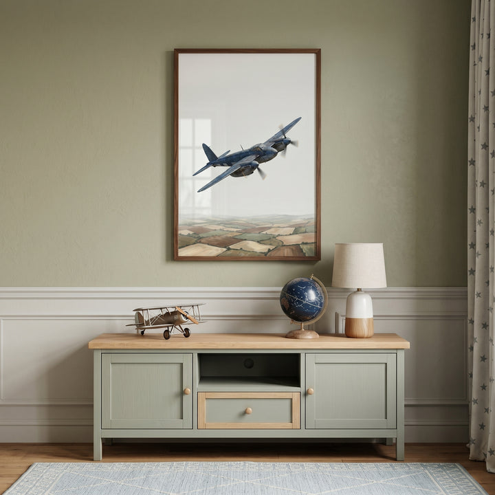 Patchwork field vintage airplane wall art hangs above a green console with a model airplane, globe, and ceramic lamp.