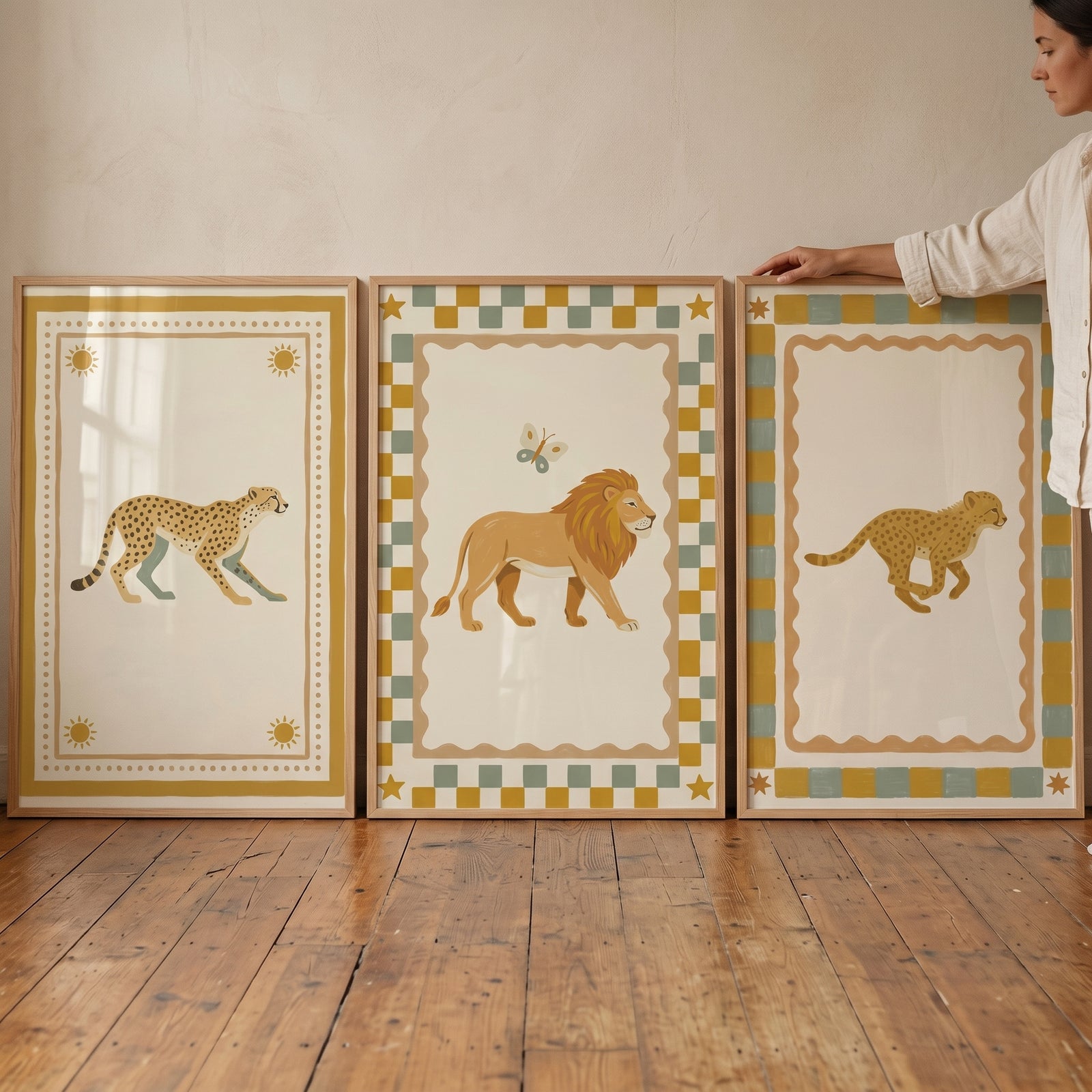 Patterned border safari animal wall art set of 3 featuring a lion and cheetahs leaning against a wall on wooden floors.
