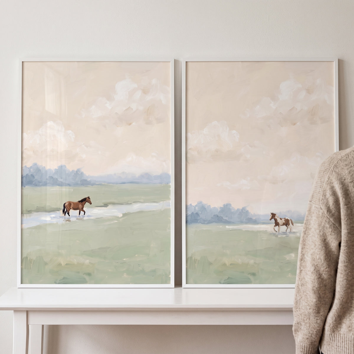 Peaceful walking pasture horse wall art set of 2 in white frames on a white console table against a plain wall.