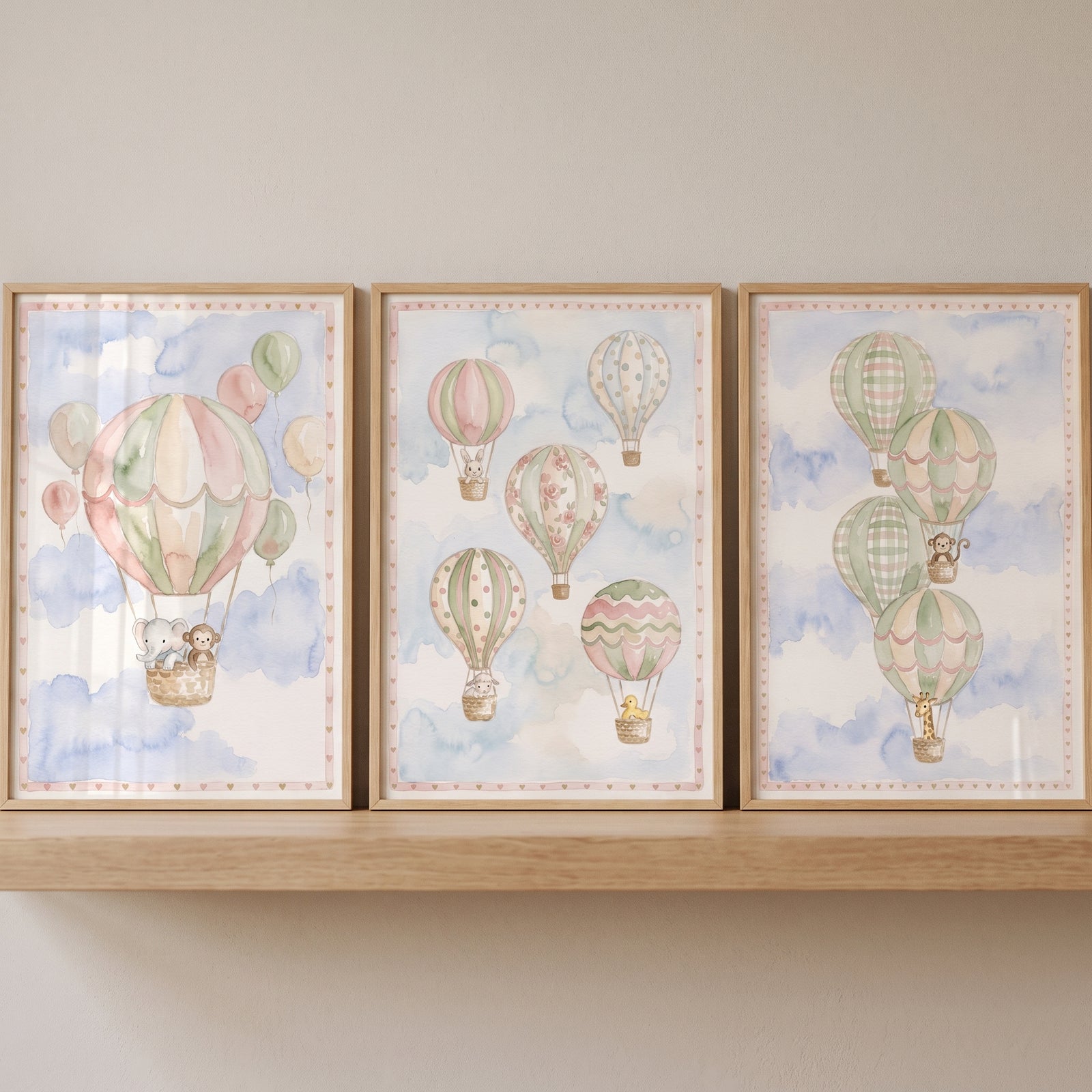 peach baby animal balloon wall art set of 3 shows watercolor hot air balloons with animals floating in a soft blue sky.