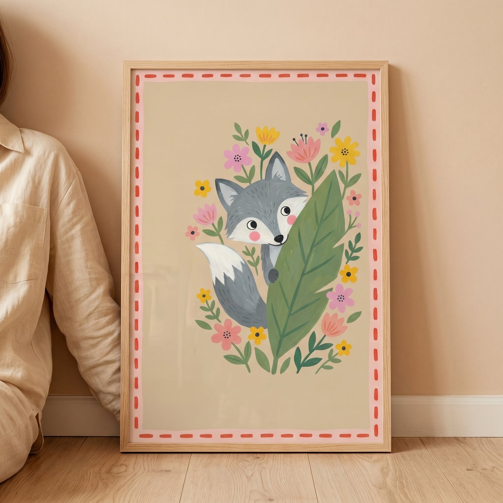 Peeking forest grey fox wall art shows a cute fox behind a large leaf surrounded by flowers in a light wood frame.