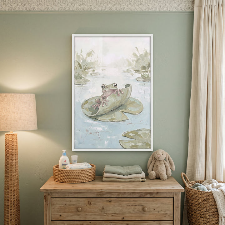 Peeking leaf green frog wall art hangs above a wood dresser with a bunny plush and wicker basket in a sage green nursery.