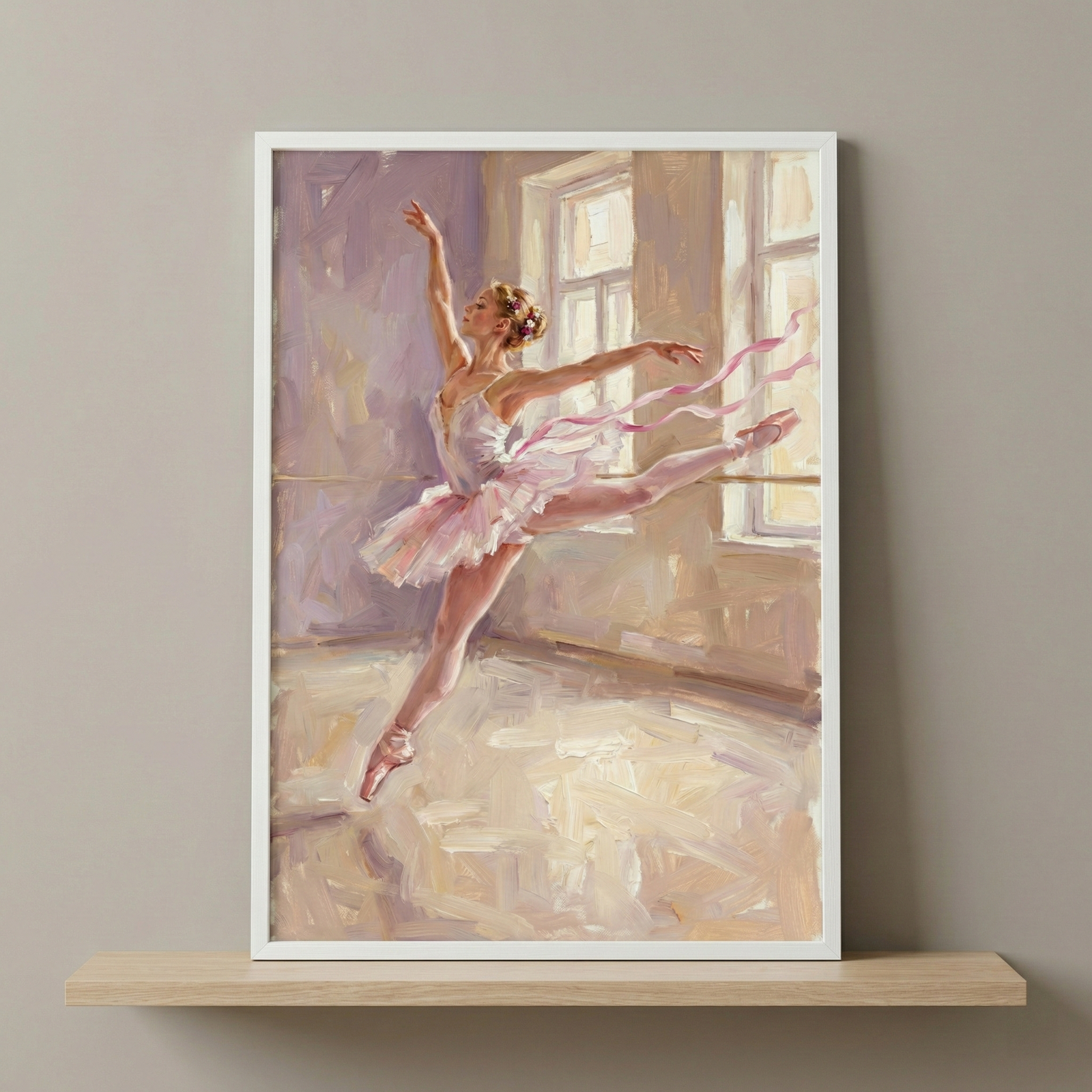 A ballerina is captured in a graceful leap within a soft, impressionistic artwork. She wears a layered pink tutu and matching pointe shoes, with ethereal pink ribbons swirling around her to emphasize motion. The setting is a sunlit studio, where light from large windows creates a luminous atmosphere. Bold, textured strokes and a palette of rose, lavender, and cream define the composition. The piece is housed in a white frame, resting on a wood shelf against a neutral gray wall.