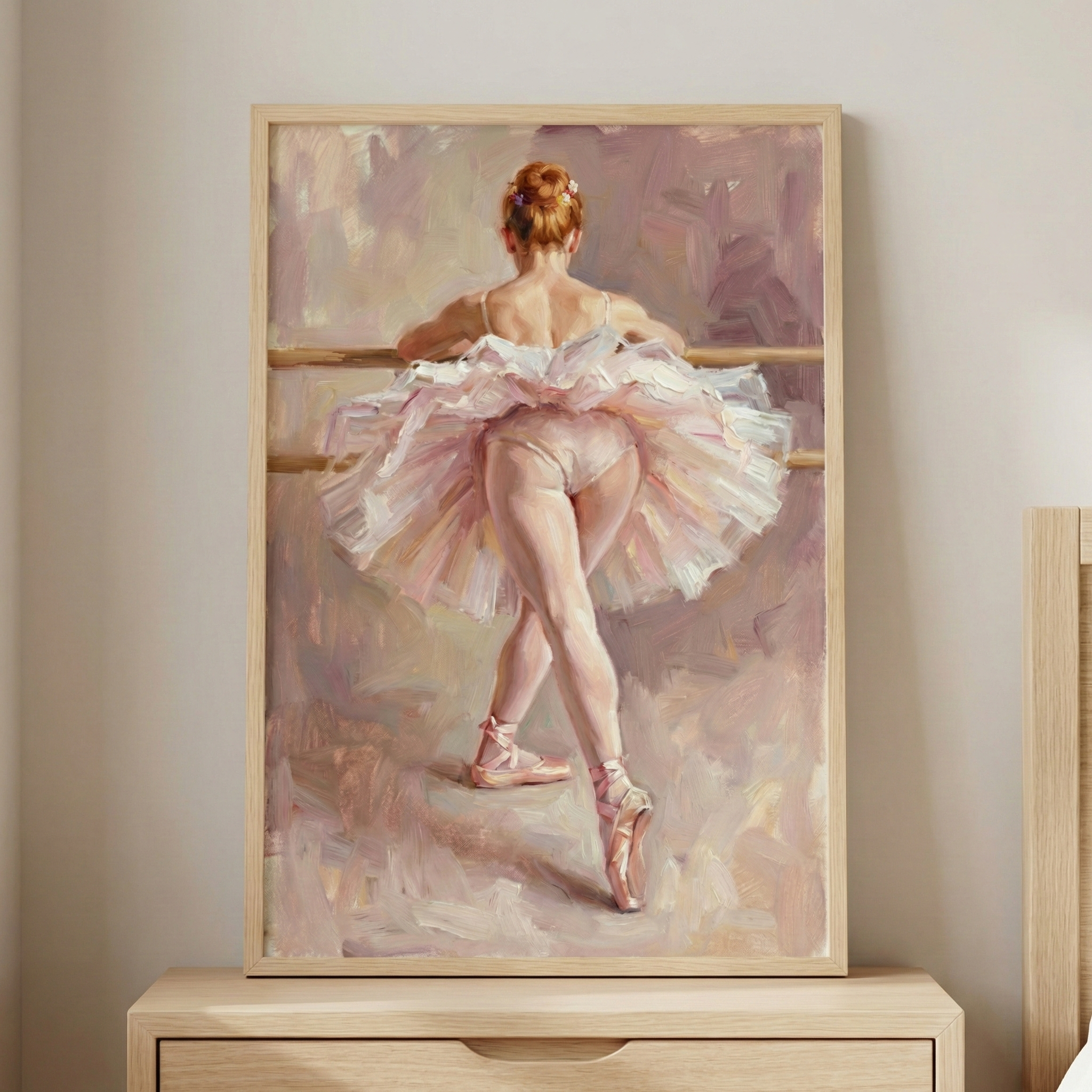 A painting of a ballerina in a tutu stands on a wooden dresser. The ballerina is seen from behind, poised gracefully on pointe, with one leg extended at the barre. The artwork features soft pastel colors, creating a delicate and elegant atmosphere.