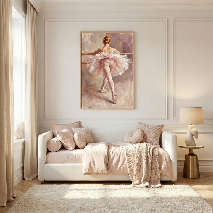 A serene, elegant room features a large framed artwork of a ballerina in a pink tutu seen from behind. Below it, a white daybed is layered with blush and cream pillows and a cozy throw. To the right, a modern lamp with a sculptural base sits on a gold pedestal table. Natural light from a curtained window spills onto a white shaggy rug and light wood floors, creating a soft, airy atmosphere. The walls are finished with classic decorative molding in a warm off-white tone.