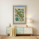Framed crocodile illustration hung above a light wood dresser with soft green drawers in a calm nursery setting. The playful jungle artwork with leafy details adds color and character alongside a small lamp, wooden toys, and a draped knit blanket.